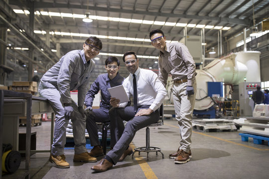Portrait of businessman and engineers in the factory