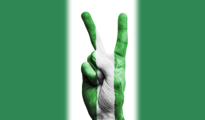 Nigeria national flag painted onto a male hand showing a victory, peace, strength sign