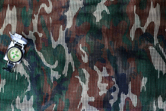 Compass on military camouflage net background