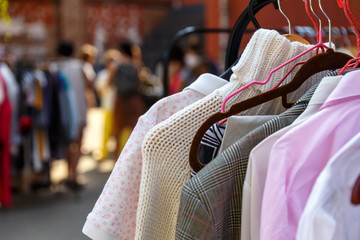 Hangers with men's and women's clothing at the garage sale
