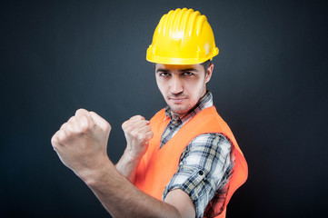 Constructor wearing equipment showing both fists like fighting