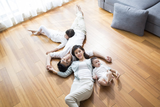 Happy young family resting on wooden floor