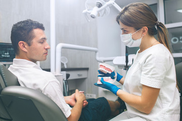 Portrait of a female dentist and young happy male patient in a dentist office. Man