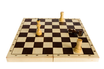 The black chess king is defeated and lies on the board.