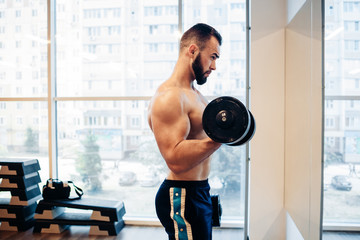 Fototapeta na wymiar Muscular guy in the gym
