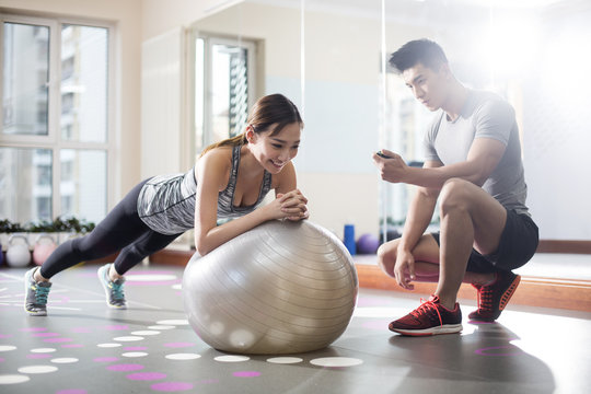 Young woman working with trainer at gym