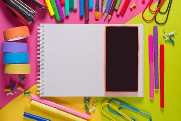 notebook and stationery tools on a bright colorful background.