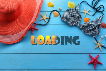 Text loading, sea female accessories (hat, swimsuit, bra) on a blue board with starfish