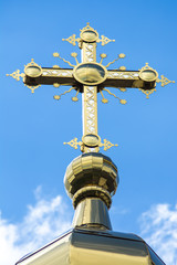 Fototapeta na wymiar Orthodox cross on a background of summer sky and clouds