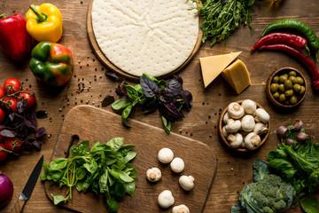 raw pizza dough and vegetables