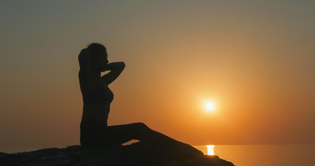 Naklejka na ściany i meble Girl practices yoga near the ocean
