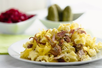 Small square shaped pasta and smoked meat baked together as typical czech meal 