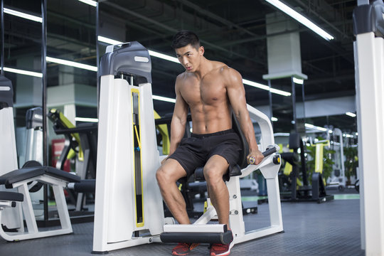 Shirtless young man exercising in gym