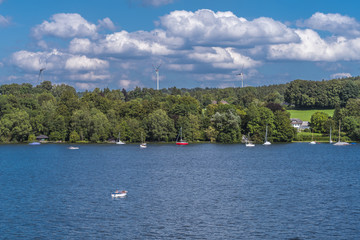 Fototapeta na wymiar Windenergieanlage hinter dem Ufer vom Starnberger See in Oberbayern