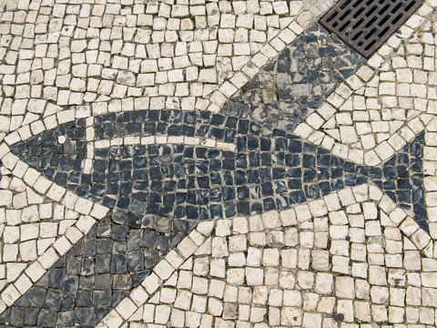 Traditional portuguese pavement (calcada portuguesa) with a fish detail in Faro, Portugal