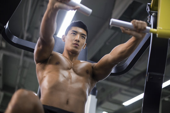 Young man exercising at gym