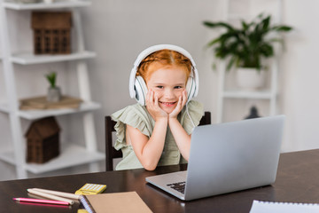 little girl with headphones and laptop