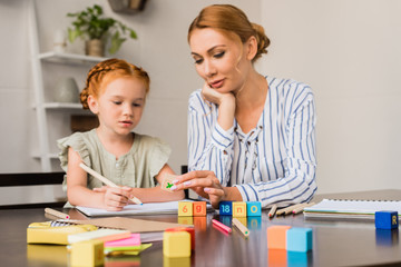 Fototapeta premium mother and daughter learning math with cubes