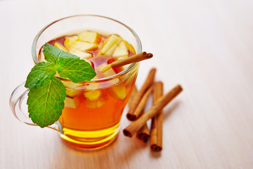 A glass of apple drink with cinnamon