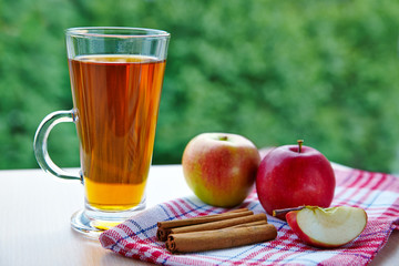 A glass of apple drink with cinnamon outdoor