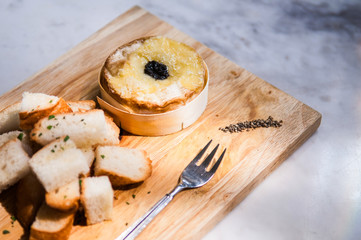 Brie cheese with bread on wooden plate