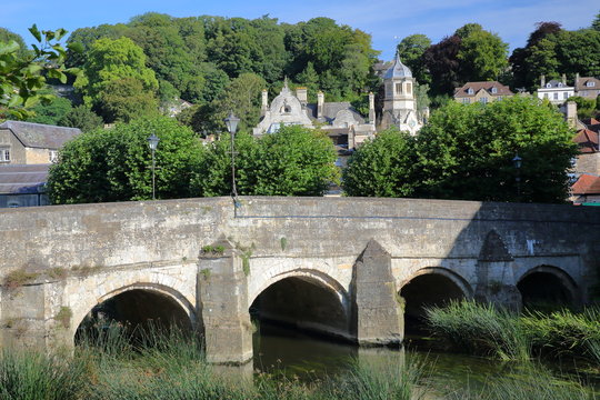 The Old Town Bridge on the river Avon with the bell tower of St Thomas More's Catholic Church in the background, Bradford on Avon, UK