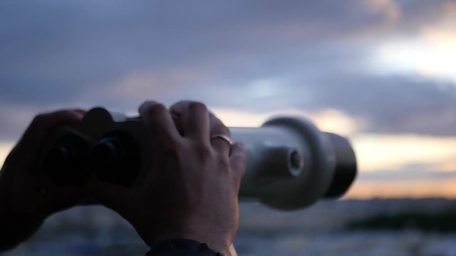 Holding binoculars in hands on sunset background, close-up. slow motion, 1920x1080, full hd