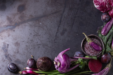 Assortment raw organic of purple vegetables mini eggplants, spring onion, beetroot, radicchio salad, plums, kohlrabi, flower salt over dark metal background. Top view with space. Food frame