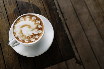 Hot latte coffee On the old wood table in the morning.Copy space for your text.