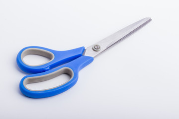 A closed pair of scissors with a blue grip