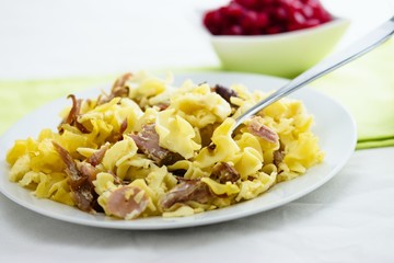 Small square shaped pasta and smoked meat baked together as typical czech meal 