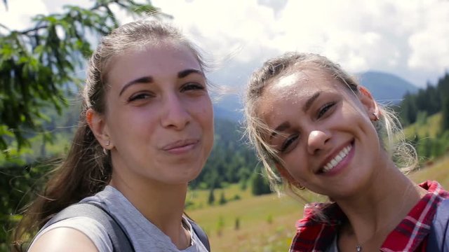 Girlfriends take pictures together in the afternoon in the mountains