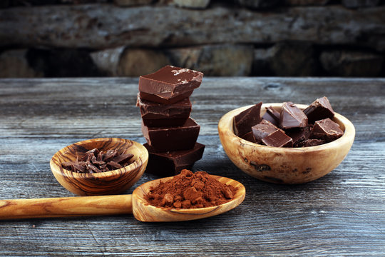Chocolate bars, chocolate pieces and chocolate powder on black