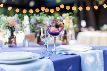 Flower table decorations for holidays and wedding dinner. Table set for holiday, event, party or wedding reception in outdoor restaurant.