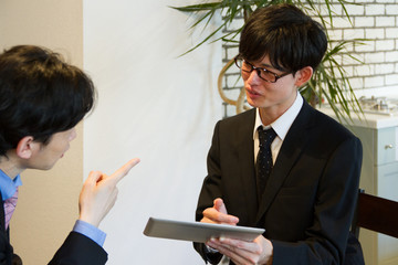 先輩からアドバイスを受ける新人ビジネスマン