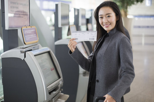 Businesswoman using ticket machine at the airport