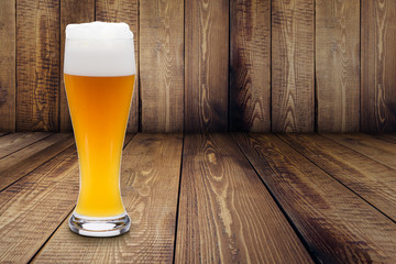 Trübes Weizenbier mit Schaumkrone auf Holzplanken