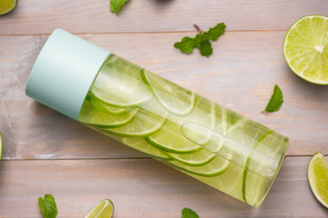 Detox Infused Water with Lime and Mint in Sports Bottle, with slices of lime.