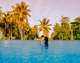 Young female in the pool on the roof on the background of Seychelles island of La Digue