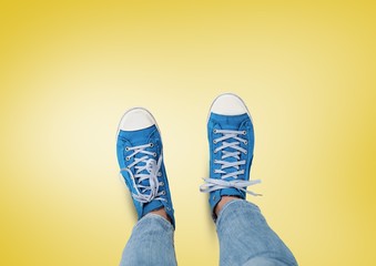 Blue shoes on feet with yellow background
