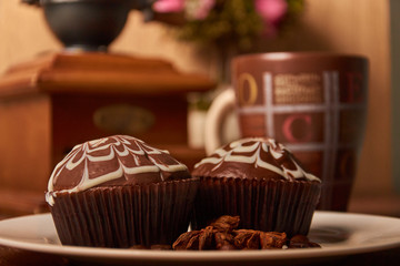 Chocolate muffins on a white plate with a brown cup