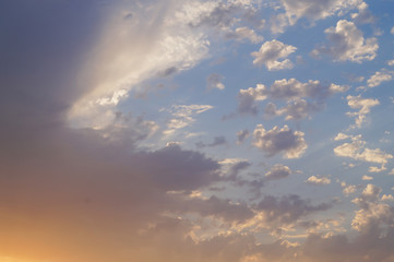 Bright yellow and grey fkuffy clouds at sunset or sunrise