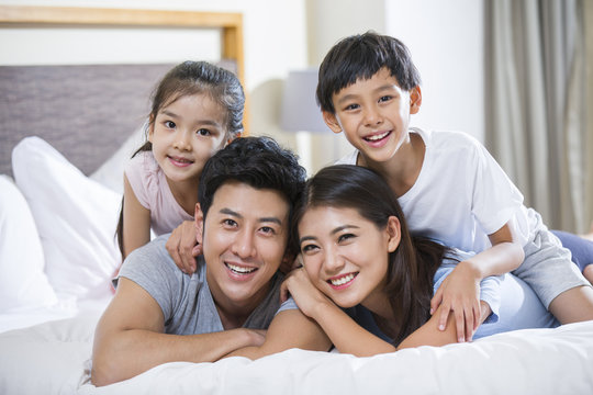 Cheerful young family on a bed