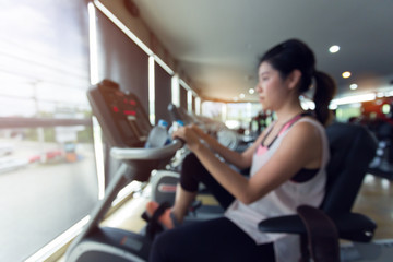Fototapeta na wymiar blurred woman cycling burn fat on bicycle cardio machine in fitness gym