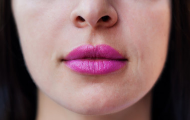 Close up photo of woman's lips with pink make up
