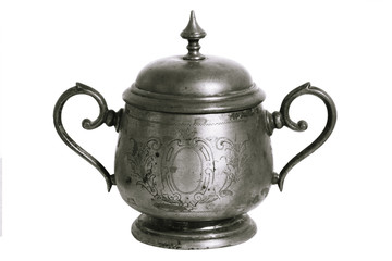An old silver metal sugar bowl with a lid and ornament. Metal punctles with scratches and patina.