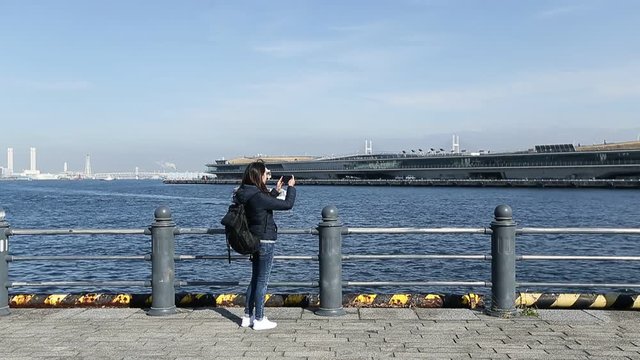 Woman travel in Yokohama bay and taking photo
