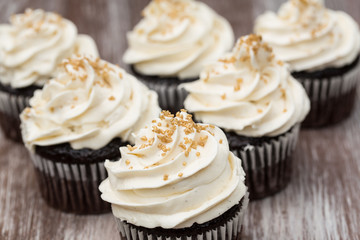 Chocolate Cupcakes With Vanilla Frosting and Gold Sprinkles