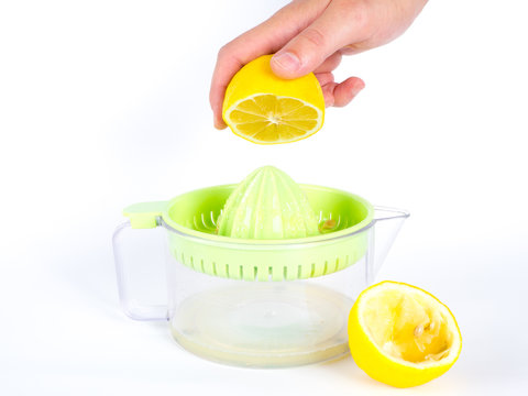 Males hand squeeze lemon on juiser