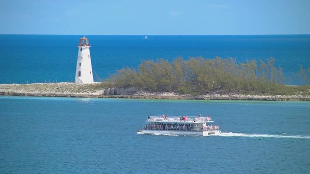 Port of Nassau Bahamas with Tourist Excursion Boat Sailing past the Iconic Lighthouse Exiting the Harbor on a Sightseeing Excursion Tour at the Popular Cruise Destination